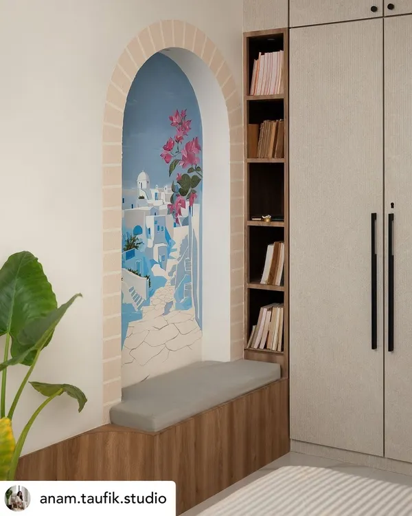 The completed Santorini mural, nestled in an arched nook with a cozy reading bench. It's a perfect example of how a mural can create a functional and imaginative feature in a room.