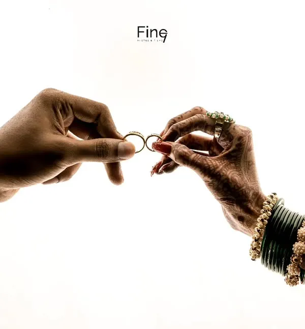 A creative and symbolic shot of the couple's hands holding their wedding rings. This highlights the commitment they are about to make.