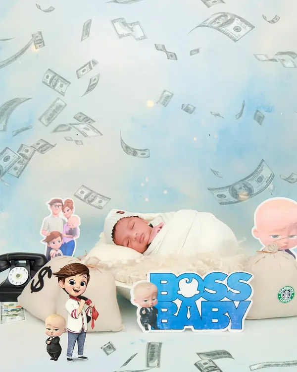 A fun and creative "Boss Baby" themed photoshoot. The baby is surrounded by prop money and characters from the movie for a playful and memorable shot.