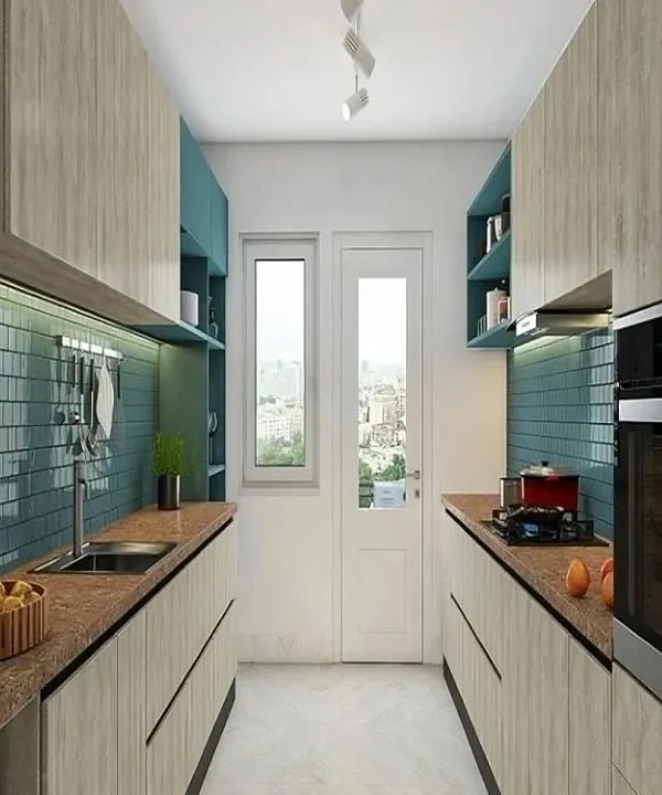 This galley kitchen is a masterclass in space efficiency. The design uses light wood-look cabinets and a contrasting teal backsplash to create visual interest, while the parallel layout provides ample counter space and storage in a narrow footprint.