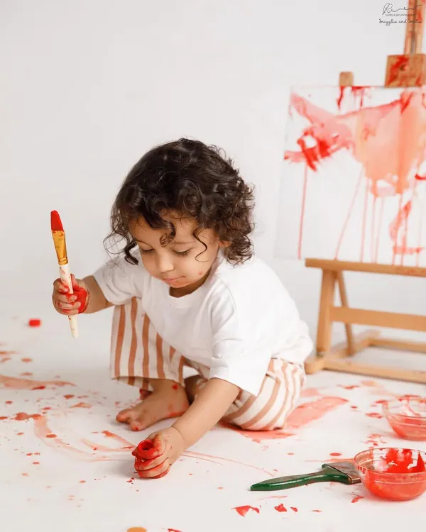 A little artist at work. A paint smash session is a fantastic and fun alternative to a cake smash, letting your child's creativity run wild.
