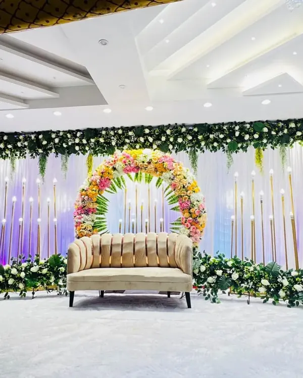 A beautiful stage setup at Grand Utsav banquet hall in Kharghar. The circular floral arrangement is the centerpiece, surrounded by candle-like lights that create a soft, romantic glow for an engagement or reception.