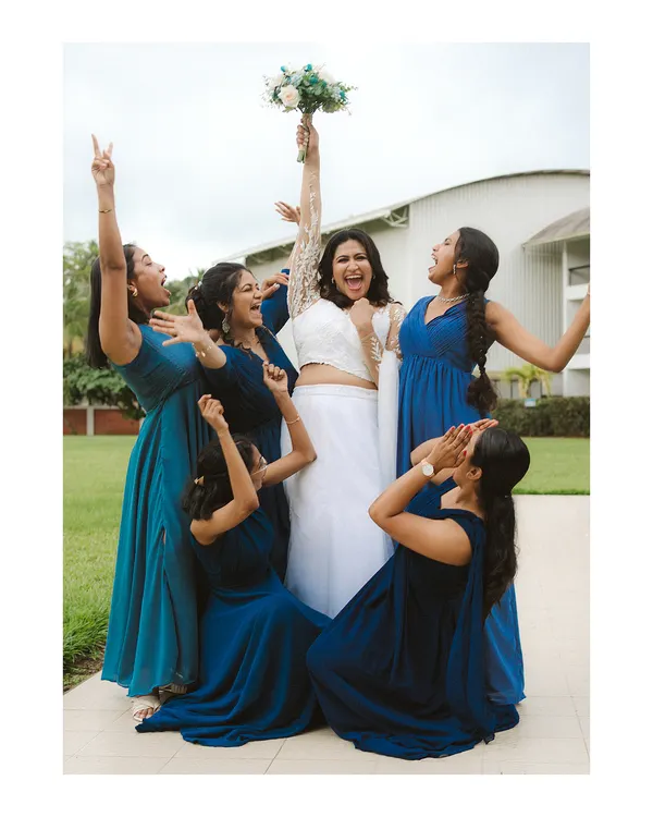 A bride and her bridesmaids erupt in celebration. This fun, energetic shot captures the joy and support of her closest friends as they cheer for her on her big day.