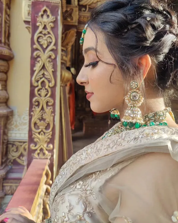 A side profile showcasing the complete look, from the intricate braided updo to the soft glam makeup. The focus is on defined eyes and a flawless profile, perfect for event photography.
