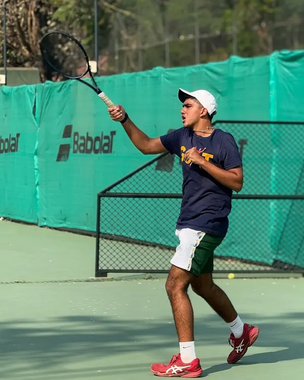 A young player demonstrates a powerful follow-through on his forehand, a key component of the technical training we provide on the hard courts.