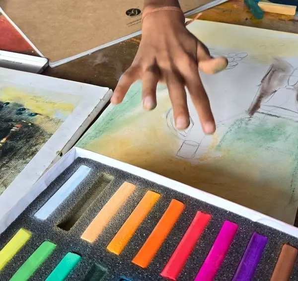 A student gets hands-on experience with dry pastels, learning to blend colors and create soft, vibrant textures. Our classes provide all the necessary materials to explore this rich and colorful medium.