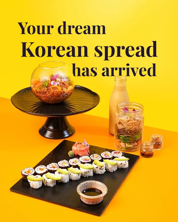 Your dream vegetarian Korean spread has arrived. This shot captures a complete meal I offer, including a platter of my fresh vegetable and avocado sushi, a Bibimbap Noodle Jar, and a refreshing drink. It's a vibrant and healthy feast.