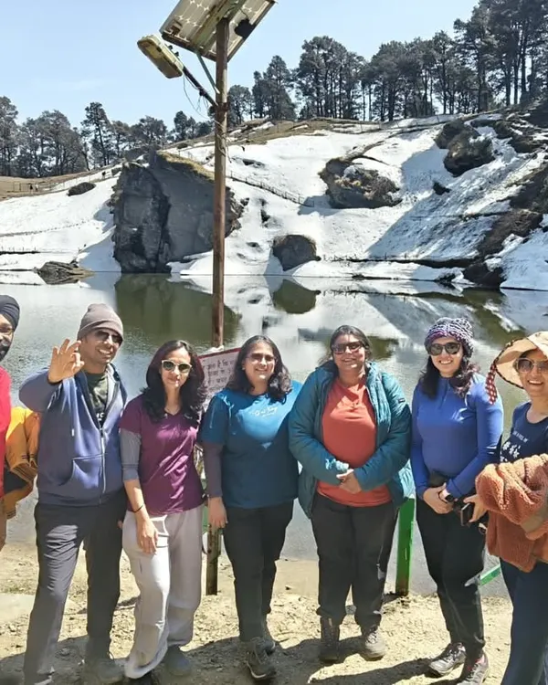 Our group at a snow-covered lake during the Jibhi & Tirthan Valley trip in the Himalayas.