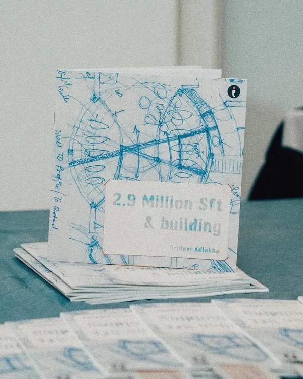 A photo of the book "2.9 Million Sft & building" by Sridevi Adlakha, which chronicles the personal and professional journey of our firm. The cover features a blueprint sketch, symbolizing our deep roots in the architectural process.