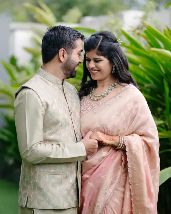 A lovely, candid portrait from an engagement day shoot. The natural green background makes their traditional outfits pop, and their gentle smiles show the happiness of the occasion.