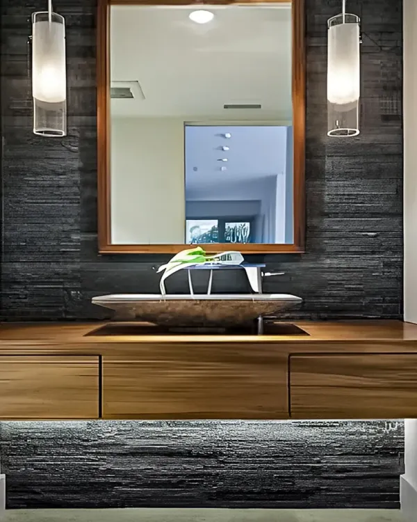 This wash area features a striking black stone accent wall. The floating wooden vanity with a vessel sink and under-cabinet lighting creates a modern and luxurious feel.