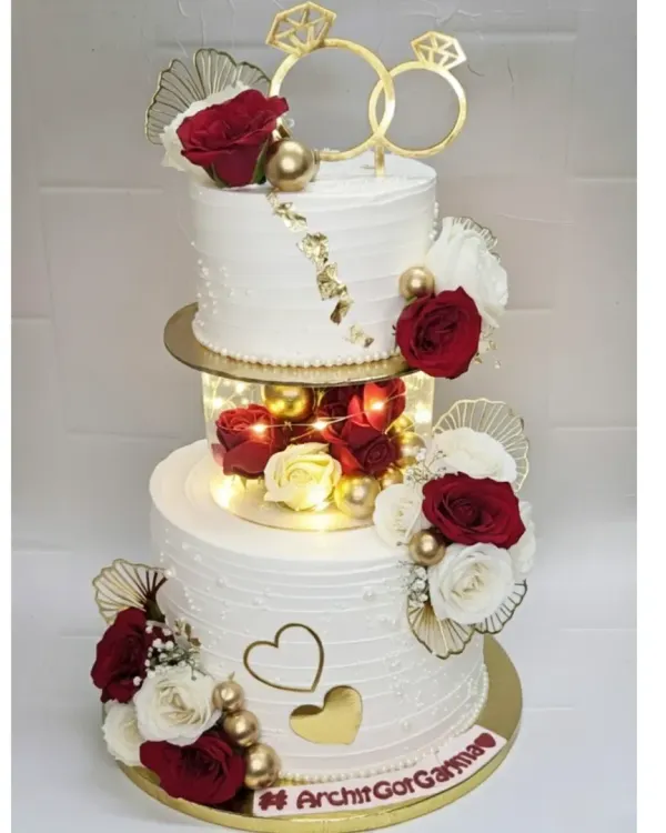 This illuminated two-tier cake was a joy to create for an engagement. It features a fresh pineapple flavor with real fruit chunks, elegant floral arrangements, and delicate gold leaf details, all brought together with a lighted spacer for that extra touch of magic.