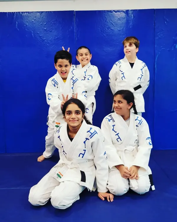 The Jiu-Jitsu squad. In their gis, these kids learn to work together, trust each other, and have fun on the mats. This is where friendships are built.