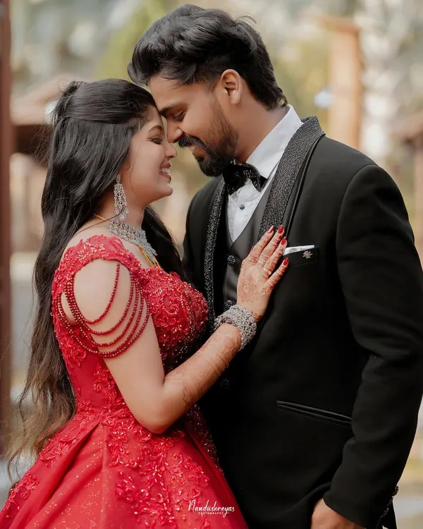 A fairytale moment from the reception. The bride in her stunning red ball gown and the groom in his classic tuxedo share an intimate embrace, full of modern romance.