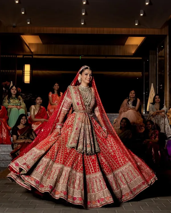 The final moment when the bride is ready. This stunning red Rimple and Harpreet lehenga was the perfect choice for a regal and timeless wedding day look. The twirl shot shows the incredible craftsmanship and grandeur of the outfit.