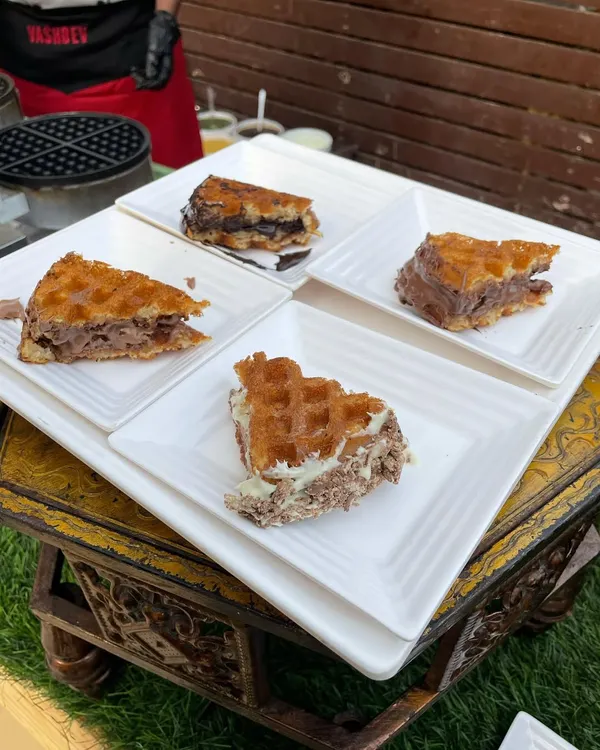 A platter of our irresistible waffles, featuring different flavors and toppings. This is a perfect dessert option that appeals to guests of all ages.