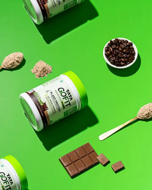 A vibrant flat lay for a plant protein brand. This top-down, patterned style is eye-catching and clearly communicates the product's ingredients like coffee and chocolate.