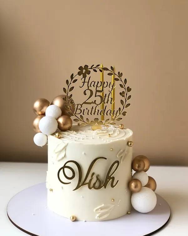 A classic and elegant 25th birthday cake in white and gold. The custom topper and delicate details make it a timeless choice.