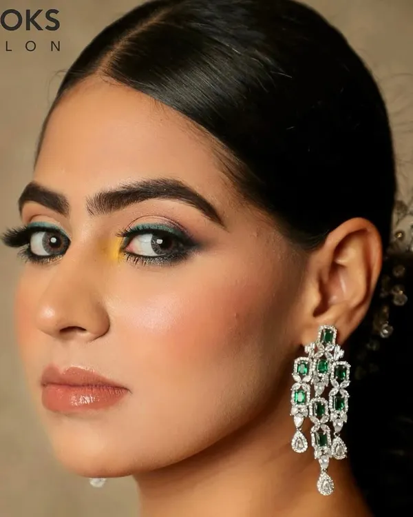 A striking party look featuring a pop of color. I used a teal and yellow eyeshadow combination for a unique and modern feel, paired with dramatic lashes and a glossy nude lip to keep the focus on the eyes.