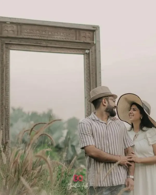 Framing their love story. A creative shot using a large empty frame as a prop in a field of tall grass.