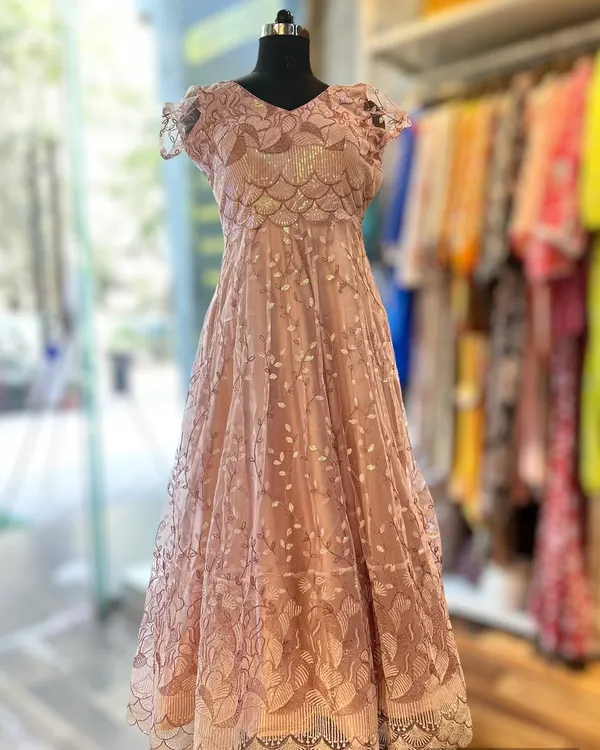 This beautiful lace gown in a dusty pink hue was tailored for a client's reception. The delicate lacework and flattering A-line silhouette create a look of timeless grace and sophistication.