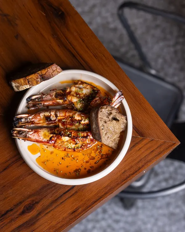 When the flames kiss the prawns and the butter starts to sizzle, there is a kind of magic that fills the air. My King Prawns are slow-cooked with garlic butter and fermented chilli, perfect for scooping up with warm sourdough.