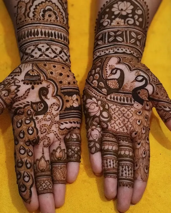 A beautiful peacock design on the palms. The peacock is a symbol of grace and beauty, making it a perfect motif for bridal mehandi.