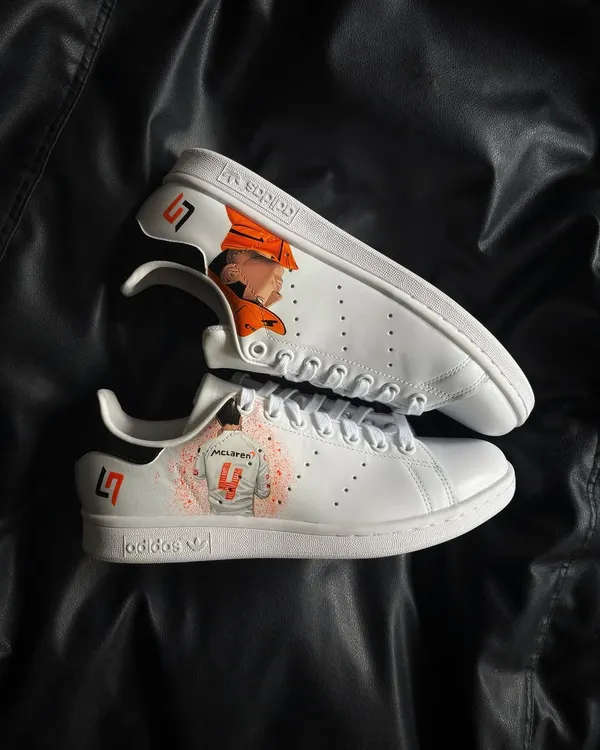 A pair of custom Adidas Stan Smiths for a McLaren F1 fan, featuring driver Lando Norris and his LN4 logo.