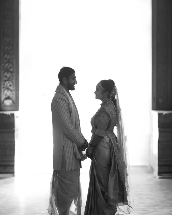 A silhouette against a stark white background. This high-contrast, minimalist black and white portrait focuses on the couple's connection and the space between them, creating a powerful, artistic statement.