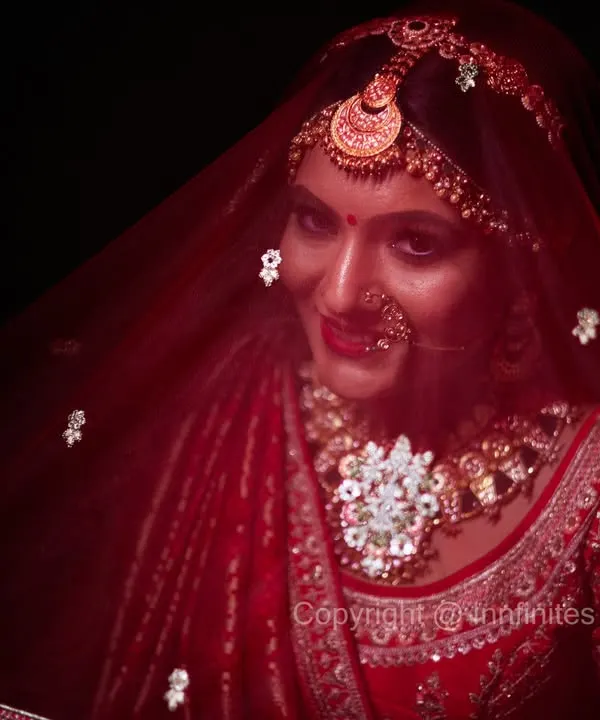 The bridal veil adds an element of mystery and elegance. I used dramatic lighting to create this stunning, moody portrait that highlights the bride's intricate jewelry and the rich color of her veil.
