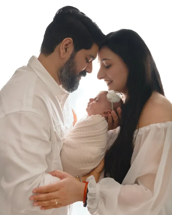 A beautiful silhouette of new parents touching foreheads while holding their newborn baby. These high-contrast, emotional shots are some of my favorites.