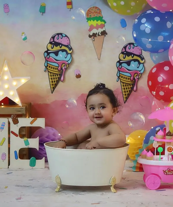 Splish, splash, it's an ice cream bath! This little one is enjoying a fun bubble bath after his cake smash session.