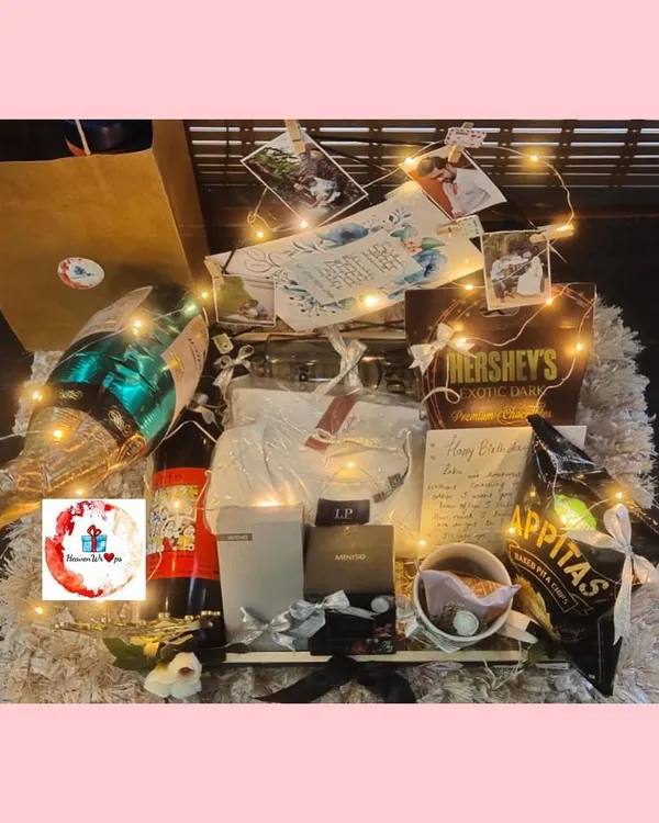 A grand hamper for the best brother. This gift is lit with fairy lights and includes a champagne bottle balloon, snacks, personalized photos, and a handwritten note.