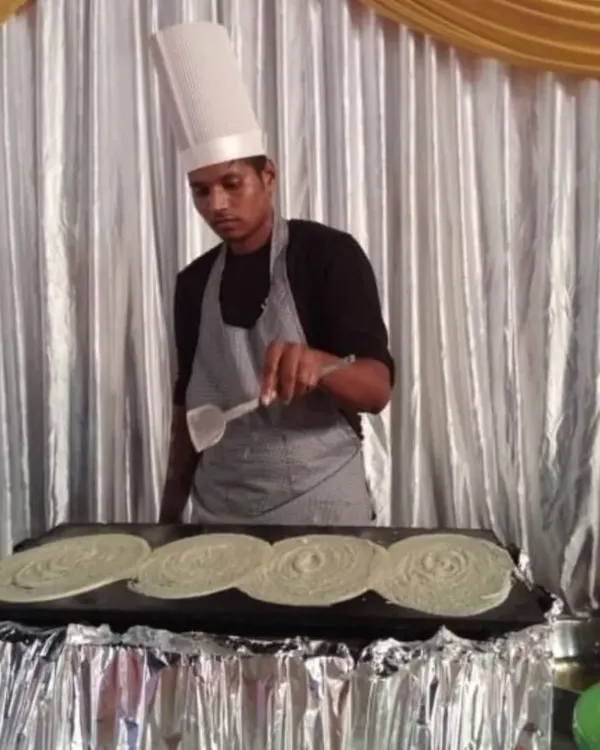 My interactive live counters are always a hit with guests. Here you can see one of my chefs preparing fresh, hot dosas on a large tawa, providing both a delicious meal and an engaging experience for everyone at the party.