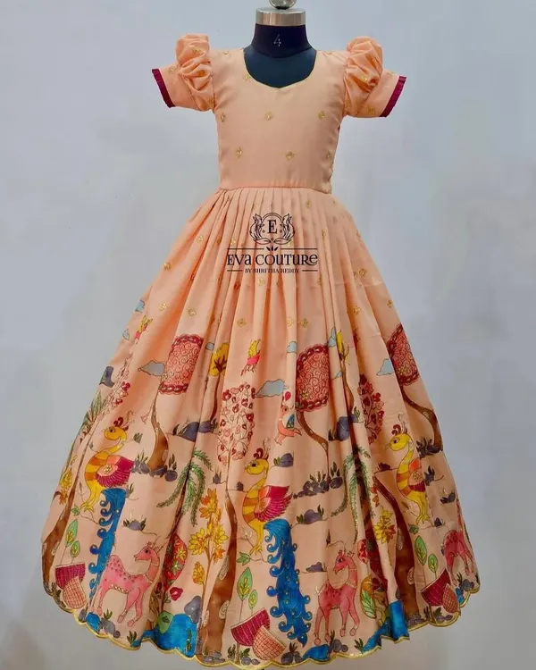 A beautiful long frock with a playful, colorful Kalamkari print. The peach color and puff sleeves make it a sweet and comfortable choice.
