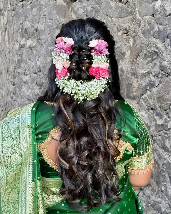 One of my favourite floral hairstyles. This half-updo is adorned with a beautiful arrangement of pink and white flowers, creating a fresh and romantic look for any bride.