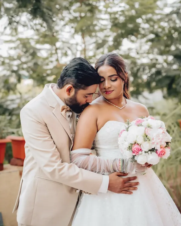 A tender moment between the groom and bride, captured outdoors. This intimate wedding portrait highlights the couple's connection in a natural setting.
