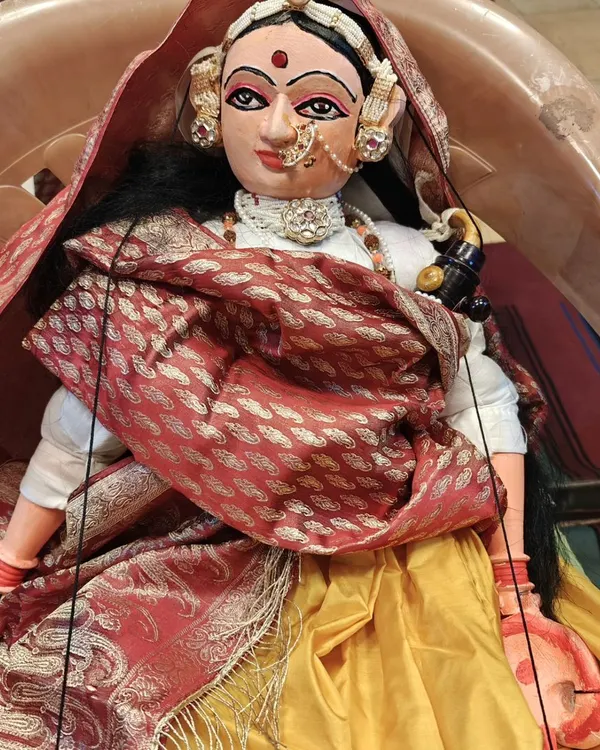 A beautifully adorned female puppet, possibly a queen or a goddess, showcasing the intricate jewelry, costume, and expressive features that are a signature of our work.
