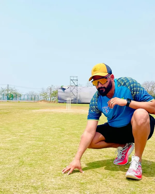 On the field, inspecting the pitch. Understanding the playing surface is a critical part of cricket strategy, a detail I emphasize in both my coaching and commentary. This is where the game is won or lost.