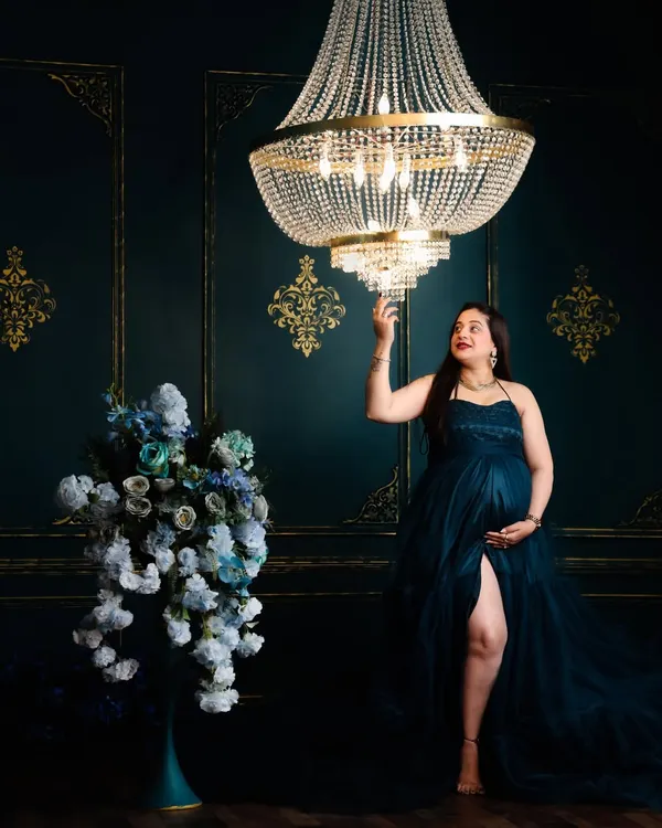 This is the kind of dramatic, elegant portrait we can create in the studio. I love using elements like this grand chandelier and a flowing gown to create a sense of magic and grandeur for the mom-to-be.