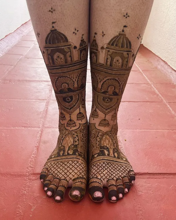 A grand and intricate design for bridal feet, featuring palace architecture, elephants, and hanging temple bells. This is perfect for the bride who wants a truly royal look.