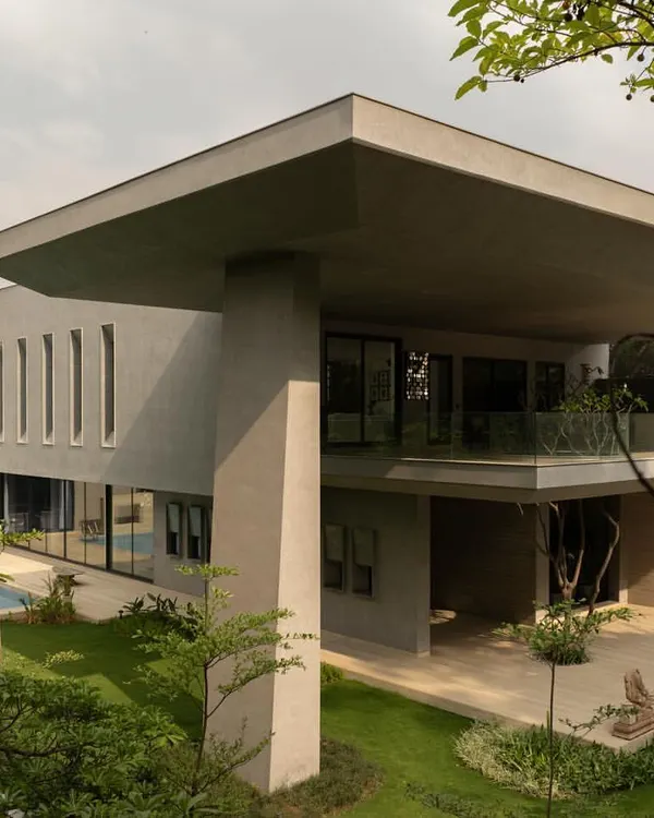 An overall view of the House Around the Oblique Column, showcasing its monumental scale and the dramatic cantilevered roof. The structure is a composition of bold, intersecting geometric planes.
