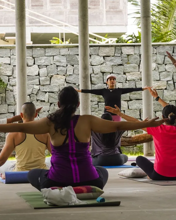 A Pilates retreat is a chance to connect with your practice on a deeper level. Here, I am guiding participants through a seated stretch, with everyone moving in unison against a backdrop of nature.
