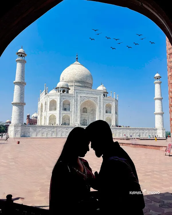 A classic silhouette against the Taj Mahal, framed by the archways. This artistic shot uses light and shadow to create a powerful, romantic image that feels both private and grand.