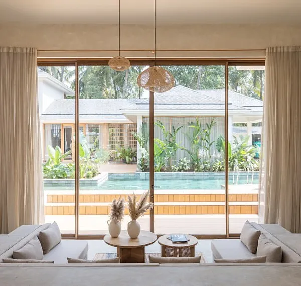 The sunken living room in the "House of Basho" is one of our favorite spaces, designed to connect you to the ground and the outdoors. Large glass panels frame a perfect view of the pool and garden, making the landscape the primary focus.