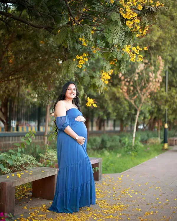 We found the most beautiful spot under the blooming amaltas trees for this outdoor maternity photoshoot. The vibrant blue of her dress against the yellow flowers felt like a celebration of new life.