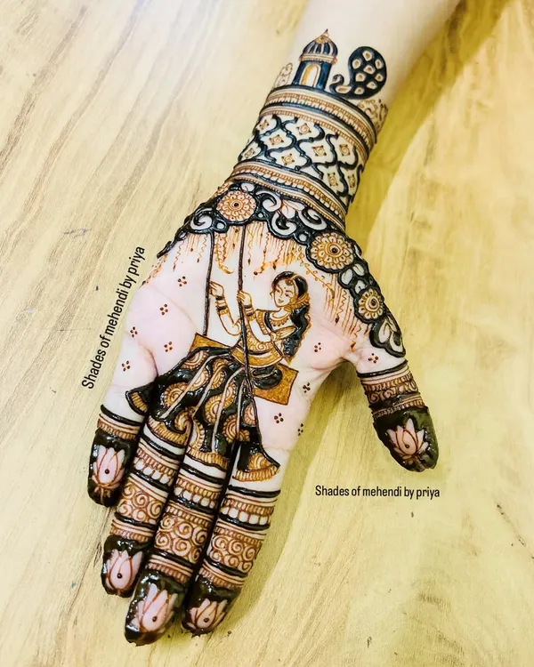 A special design for the Teej festival, featuring a woman on a swing (jhula). The hand is filled with intricate patterns, and the fingertips have a classic lotus design.