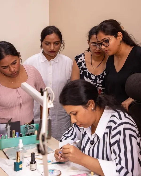 A moment of intense focus during a live demonstration. My students gather close to see every detail of the brushwork, which is crucial for learning intricate designs.