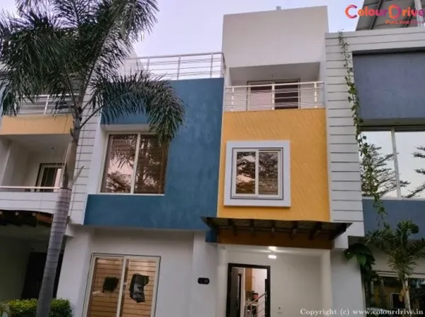 This modern villa's exterior was transformed with a durable, weather-resistant paint combination. We used a sophisticated palette of blue, yellow, and white to enhance the building's architectural features and provide long-lasting curb appeal.