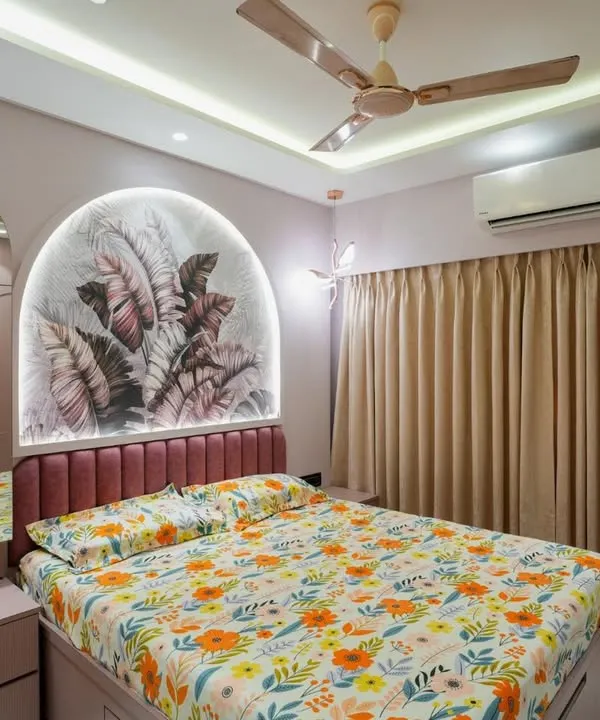 A beautiful bedroom featuring a custom arched headboard with a tropical wallpaper insert and integrated lighting. The pink upholstered bed frame adds a soft, luxurious touch.